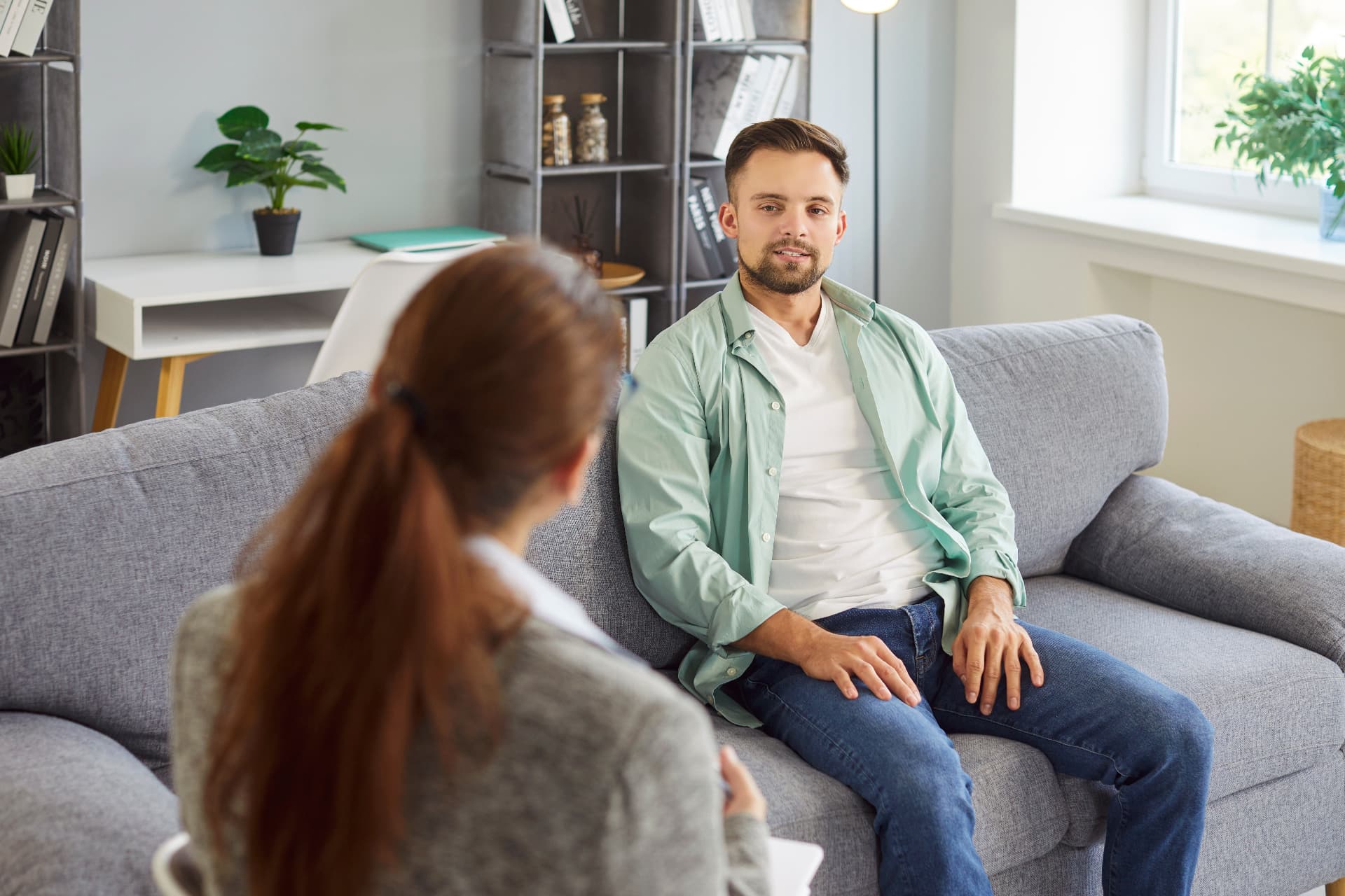 A Quovus clinician speaking with a client in a calm, naturally lit therapy room